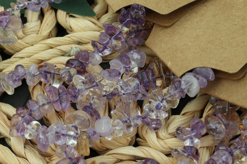 Close-up of a Ametrine bracelet with purple gemstones on a woven surface