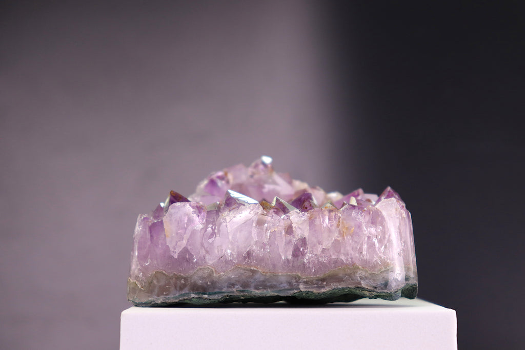 Amethyst crystal cluster on a gray background