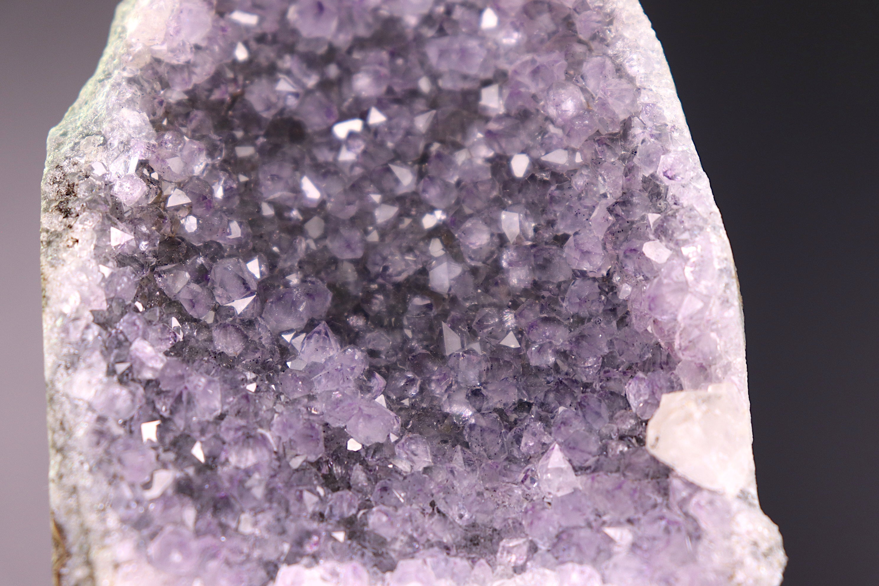 Close-up of a purple amethyst crystal formation on a dark background
