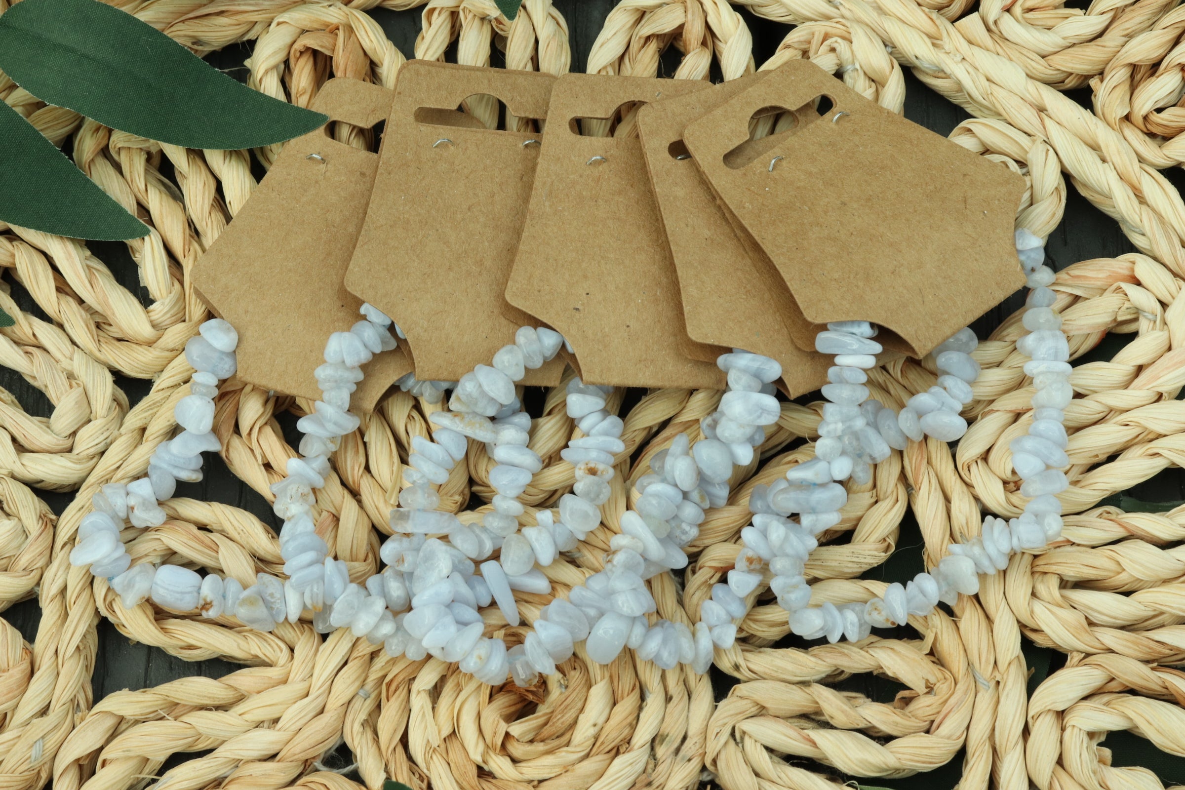 Set of blue lace agate bracelets on brown paper cards against a woven mat background