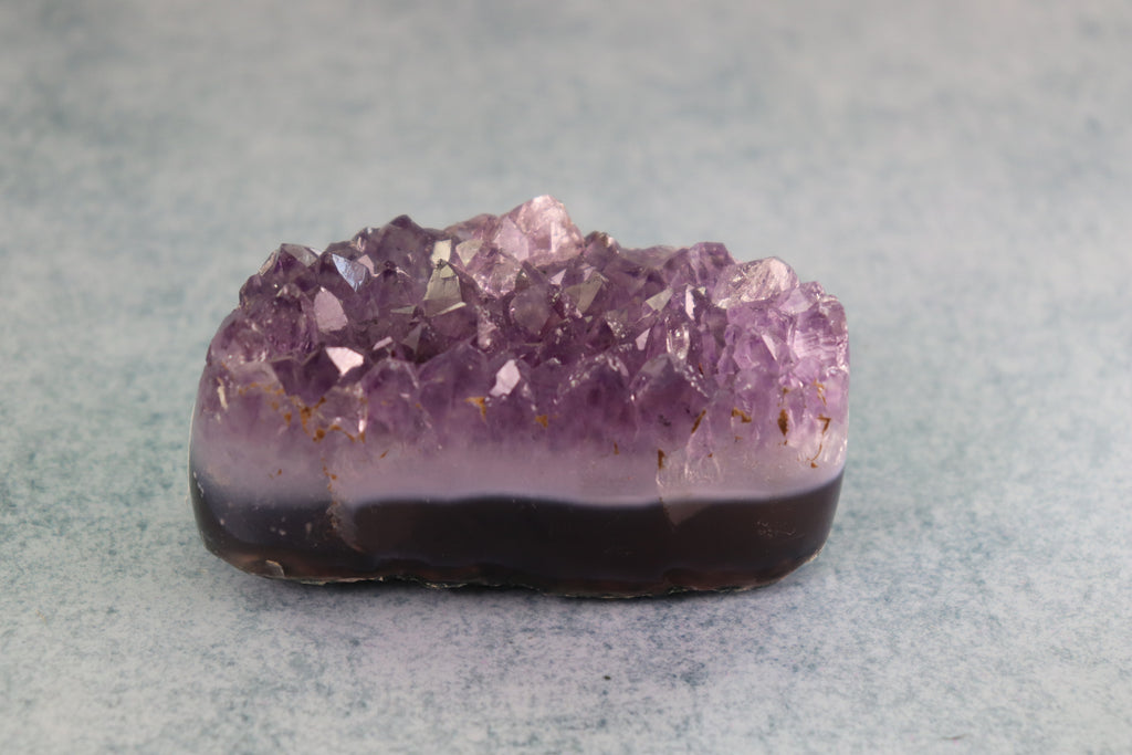 Amethyst crystal on a gray background