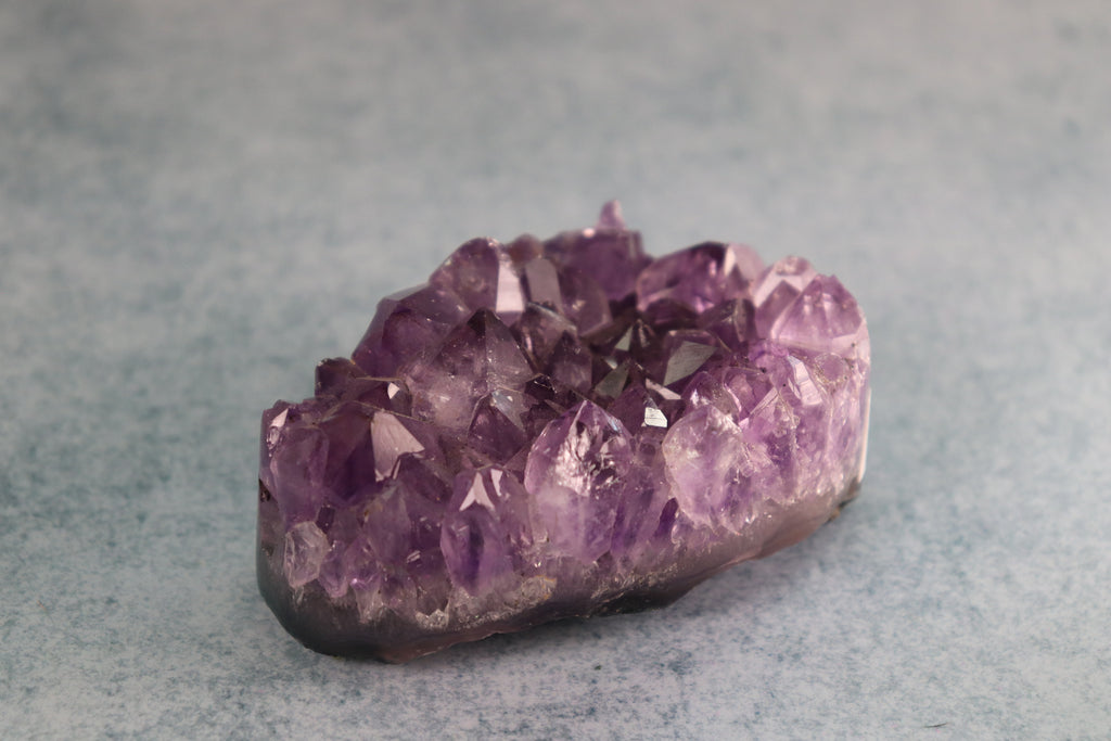 Amethyst crystal on a gray background