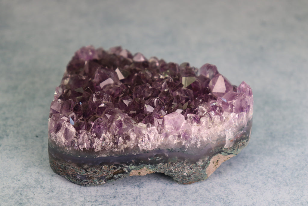 Amethyst crystal cluster on a gray background