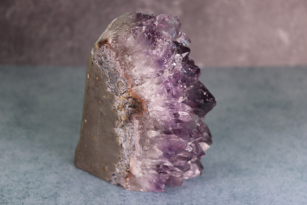 Amethyst crystal on a gray background