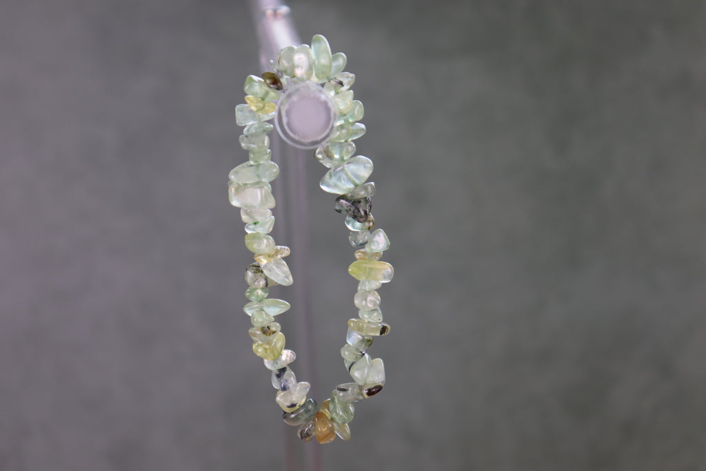 Beaded chip bracelet with multicolored prehnite stones on a gray background