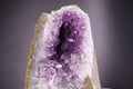 Amethyst crystal with a dark center on a gray background