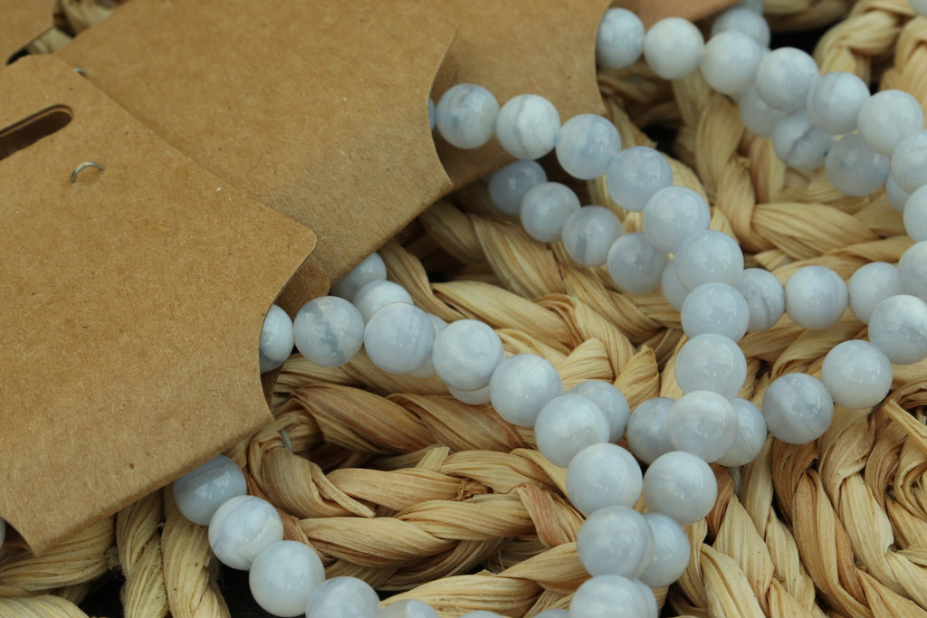 blue lace agate beaded bracelet  on a woven surface with a brown tag