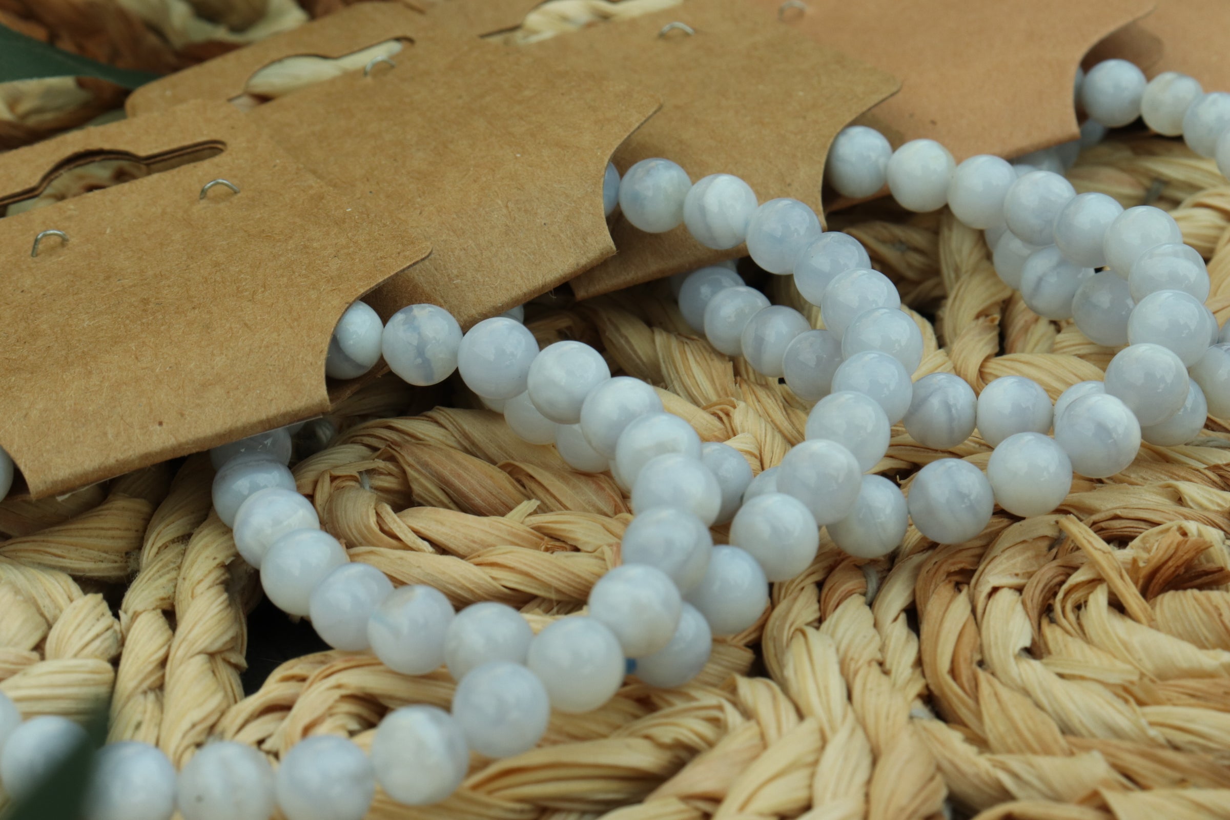 blue lace agate beaded bracelet  on a woven surface with a brown tag