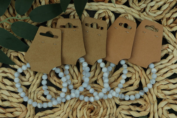 Set of blue lace agate bracelets on a textured woven surface with a white beaded necklace.