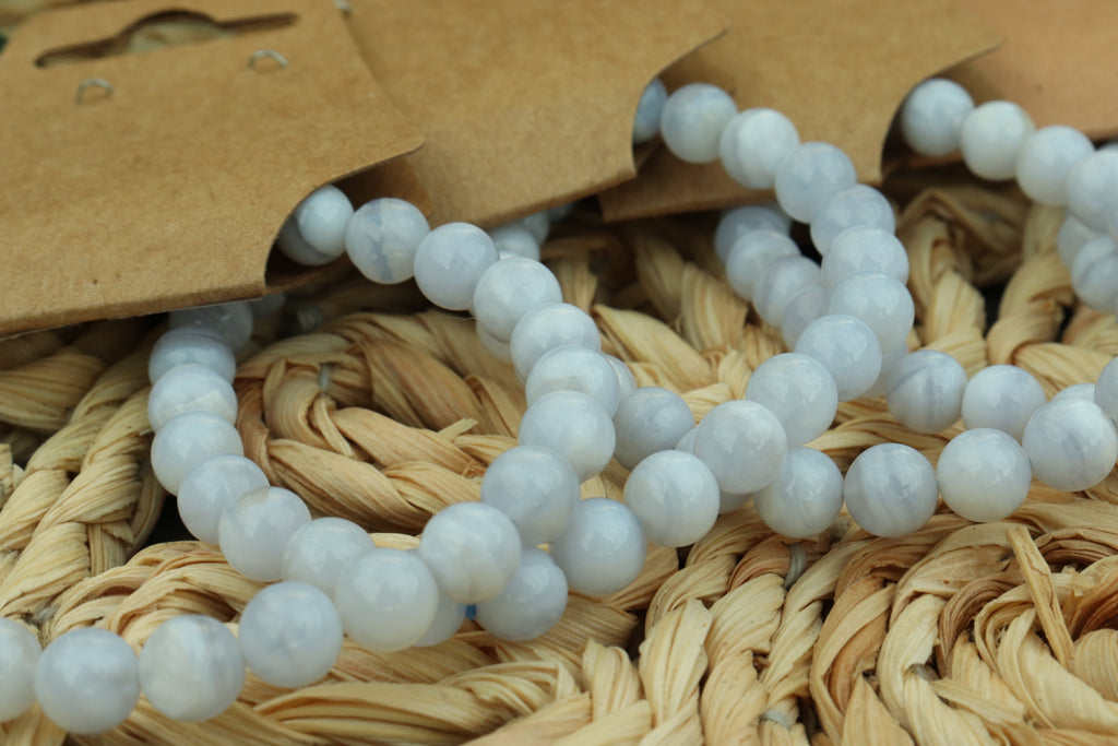 blue lace agate beaded bracelet  on a woven surface with a brown tag