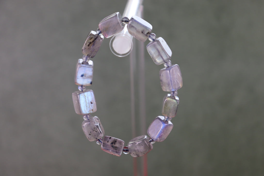 Labradorite bracelet on a stand with a neutral background