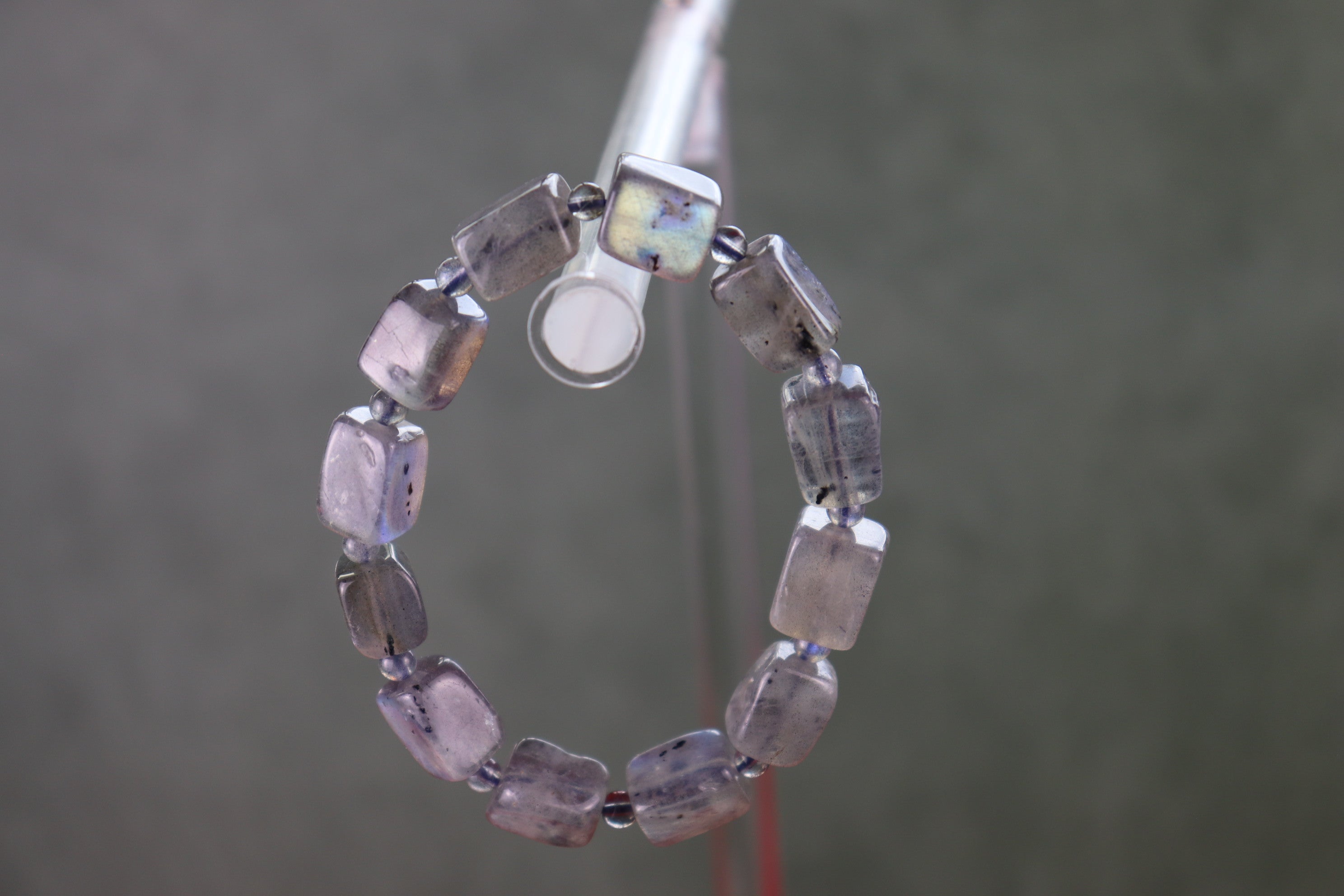 Labradorite bracelet with purple and clear beads on a gray background