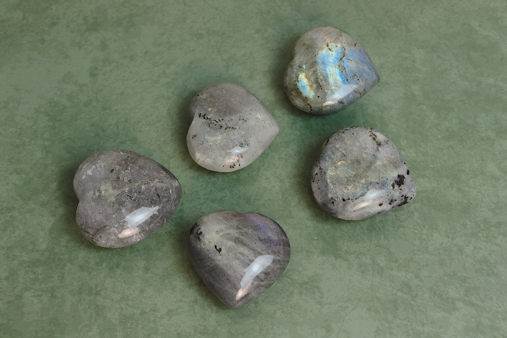 Five labradorite stones on a green background