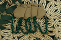 malachite chip bracelet on brown paper tags against a woven mat background