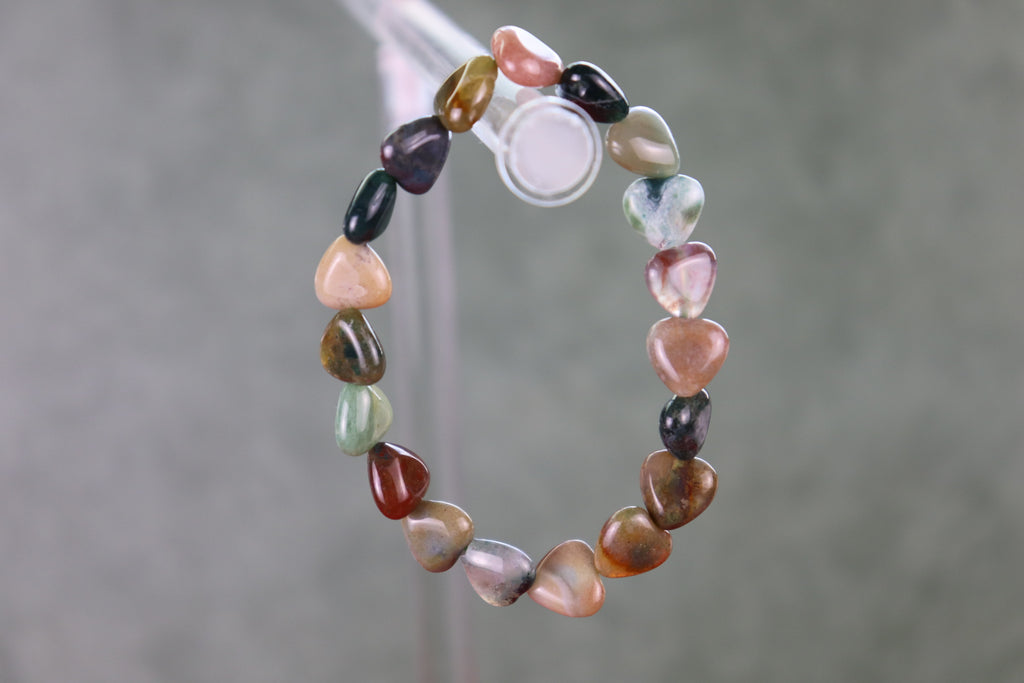 Mixed Agate heart shaped beaded bracelet on a gray background