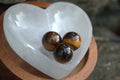 Three tiger's eye stones on a heart-shaped crystal